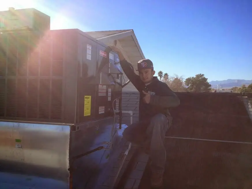 HVAC technician performing AC Tune-Up on a rooftop unit in Prospect Heights